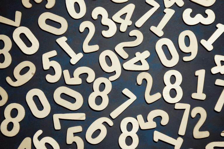 Numerical wooden figures, symbols representing spirituality and numerology, concepts central to personal development and spiritual journey.